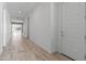 Long hallway with wood-look tile, white walls, and a view of the living room and pool area at 3260 W Caleb Rd, Phoenix, AZ 85083