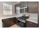 Close-up of the kitchen featuring stainless steel appliances, white countertops, and dark brown cabinetry at 3260 W Caleb Rd, Phoenix, AZ 85083