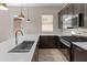 Modern kitchen featuring stainless steel appliances, a large sink, stone countertops, and dark cabinetry at 3260 W Caleb Rd, Phoenix, AZ 85083