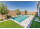 Backyard pool featuring travertine tile and artificial turf at 3260 W Caleb Rd, Phoenix, AZ 85083