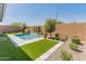 Backyard pool featuring travertine tile and artificial turf at 3260 W Caleb Rd, Phoenix, AZ 85083