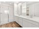 Modern bathroom featuring a dual sink vanity with wood look floors and a glass enclosed shower at 3264 W Caleb Rd, Phoenix, AZ 85083