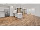 Open-concept kitchen with white island, stainless steel appliances, and wood-look flooring at 3264 W Caleb Rd, Phoenix, AZ 85083