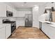 Bright kitchen with white cabinets, stainless steel appliances, a kitchen island, and wood-look flooring at 3264 W Caleb Rd, Phoenix, AZ 85083