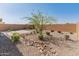 Low-maintenance backyard with rock features and mature trees, providing a serene outdoor space at 3268 W Caleb Rd, Phoenix, AZ 85083