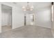 Bright bedroom with neutral carpet, a modern chandelier, walk-in closet, and ensuite bathroom at 3268 W Caleb Rd, Phoenix, AZ 85083