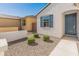 Close-up view of the charming front yard with stone and green shrubbery leading to the front door at 3268 W Caleb Rd, Phoenix, AZ 85083