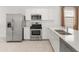 Modern kitchen with stainless steel appliances, white cabinets, and a view of the backyard at 3268 W Caleb Rd, Phoenix, AZ 85083