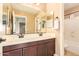 Bathroom featuring a double sink vanity, a large mirror, and a neutral color scheme at 3443 E Jasper Dr, Gilbert, AZ 85296