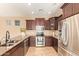 Well-equipped kitchen with stainless steel appliances and dark wood cabinets at 3443 E Jasper Dr, Gilbert, AZ 85296