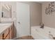 Clean bathroom with a tub, a sink with cabinets, and a decorative mirror at 3488 S Bowman Rd, Apache Junction, AZ 85119