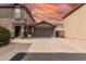 Well-maintained two-story home featuring a two-car garage, low-maintenance landscaping, and a neutral exterior under a colorful sky at 3488 S Bowman Rd, Apache Junction, AZ 85119