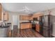 This kitchen features wood cabinets, sleek black appliances, and laminate floors at 3488 S Bowman Rd, Apache Junction, AZ 85119