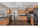 Cozy kitchen featuring ample wooden cabinets, black countertops, and stainless steel refrigerator at 3488 S Bowman Rd, Apache Junction, AZ 85119