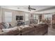 Inviting living room with a sectional sofa, ceiling fan, and an entertainment center. Dining area in background at 3488 S Bowman Rd, Apache Junction, AZ 85119
