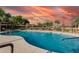 Well-maintained community pool with clear blue water surrounded by lush landscaping at 3488 S Bowman Rd, Apache Junction, AZ 85119
