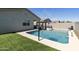 The pool has a basketball hoop and water feature and is surrounded by artifical turf at 3914 E French Trotter St, San Tan Valley, AZ 85140