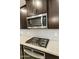 Close-up of kitchen with stainless steel microwave and gas cooktop above electric oven range at 3914 E French Trotter St, San Tan Valley, AZ 85140