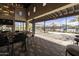 Stylish outdoor lounge with a stone fireplace, TV, and dining area overlooking the pool and playground at 3914 E French Trotter St, San Tan Valley, AZ 85140