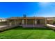 Well-maintained backyard with green lawn, covered patio, and lovely flowering bushes at 4004 W Myrtle Ave, Phoenix, AZ 85051