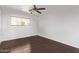 A clean bedroom featuring a ceiling fan, a window and hardwood floors at 4004 W Myrtle Ave, Phoenix, AZ 85051