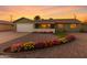 Charming one-story home featuring colorful flower beds, a well-maintained gravel yard, and a two-car garage at 4004 W Myrtle Ave, Phoenix, AZ 85051