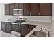 Well-equipped kitchen featuring granite countertops, a stainless steel sink, and stainless steel appliances at 42875 W Vincent Dr, Maricopa, AZ 85138
