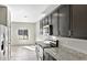Modern kitchen featuring dark cabinetry, granite countertops, stainless steel appliances, and tile flooring at 42875 W Vincent Dr, Maricopa, AZ 85138