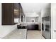Spacious kitchen featuring dark cabinetry, stainless steel appliances, granite countertops, and a tile backsplash at 42875 W Vincent Dr, Maricopa, AZ 85138