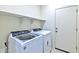 The laundry room features modern washer and dryer with storage shelves at 42875 W Vincent Dr, Maricopa, AZ 85138