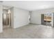 Open-concept living room featuring tile flooring, neutral walls, and a sliding glass door leading to the patio at 42875 W Vincent Dr, Maricopa, AZ 85138