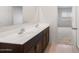 Modern bathroom featuring a double vanity, quartz countertop and dark wood cabinetry at 42900 W Peters Dr, Maricopa, AZ 85138