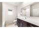 Bright bathroom featuring a dark wood vanity, white countertops, and large mirror at 42925 W Palo Amarillo Rd, Maricopa, AZ 85138