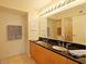 Bright bathroom featuring dual sinks, black countertop, and large mirror with vanity lighting at 4808 N 24Th St # 204, Phoenix, AZ 85016