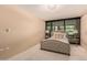 Bright bedroom featuring a tufted headboard bed and large window overlooking the lush community at 4808 N 24Th St # 204, Phoenix, AZ 85016
