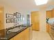 Open-concept kitchen with stainless steel sink, sleek cabinets, and tile flooring at 4808 N 24Th St # 204, Phoenix, AZ 85016