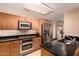 Kitchen featuring modern stainless steel appliances, granite countertops, and wooden cabinets at 4808 N 24Th St # 204, Phoenix, AZ 85016