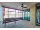 This screened patio features tiled flooring, a ceiling fan and a view of the nearby trees and city at 4808 N 24Th St # 204, Phoenix, AZ 85016