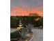Beautifully landscaped backyard featuring a fountain, desert plants, and vibrant sunset views at 5336 E Gloria Ln, Cave Creek, AZ 85331