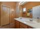 Warm-toned bathroom with double sinks, wooden cabinets, framed mirrors, and separate doors at 5336 E Gloria Ln, Cave Creek, AZ 85331
