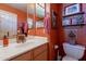 Bright bathroom with warm terracotta walls, decor, white sink, and toilet at 5336 E Gloria Ln, Cave Creek, AZ 85331