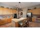 Spacious kitchen featuring an island with cooktop, stainless steel appliances, and light wood cabinets at 5336 E Gloria Ln, Cave Creek, AZ 85331