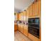 Kitchen showcasing light wood cabinets, tile backsplash, and built-in black oven and microwave at 5336 E Gloria Ln, Cave Creek, AZ 85331