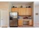 Kitchen showcasing stainless steel refrigerator, wooden cabinets, and a built-in desk area at 5336 E Gloria Ln, Cave Creek, AZ 85331