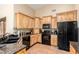 Modern kitchen showcasing wood cabinets, granite countertops, and black appliances for a sleek design at 5536 E Gable Ave, Mesa, AZ 85206