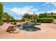 Resort-style pool with a rock waterfall, surrounded by a spacious patio and lush landscaping at 5536 E Gable Ave, Mesa, AZ 85206