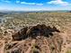 Scenic aerial view features a rocky outcrop, desert vegetation, and a distant cityscape at 6055 E Vernon Ave, Scottsdale, AZ 85257