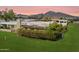 Aerial view of backyard with lush green lawn, patio with pergola, and mountain views in the distance at 6055 E Vernon Ave, Scottsdale, AZ 85257