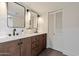 Modern bathroom featuring double sinks, stylish wood cabinets, and modern light fixtures at 6055 E Vernon Ave, Scottsdale, AZ 85257