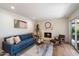 Living room featuring a cozy blue couch, fireplace, and sliding glass doors leading to the outdoors at 6055 E Vernon Ave, Scottsdale, AZ 85257